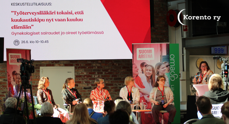 Kuva paneelikeskustelusta: lavalla keskustelijat vasemmalta oikealle: Eliisa Tornberg, Tiia Tuovinen, Terhi Piltonen, Elina Kynnysmaa sekä Salome Tuomaala-Özdemir. Oikeassa reunassa juontaja: Rosa Meriläinen. Puhujien taustalla näyttö, jossa tilaisuuden otsikko: "Työterveyslääkäri tokaisi, että kuukautiskipu vaan kuuluu elämään - gynekologiset sairaudet ja oireet työelämässä. Kuvassa näkyy myös puhujalavan edustalla olevia katsojia.